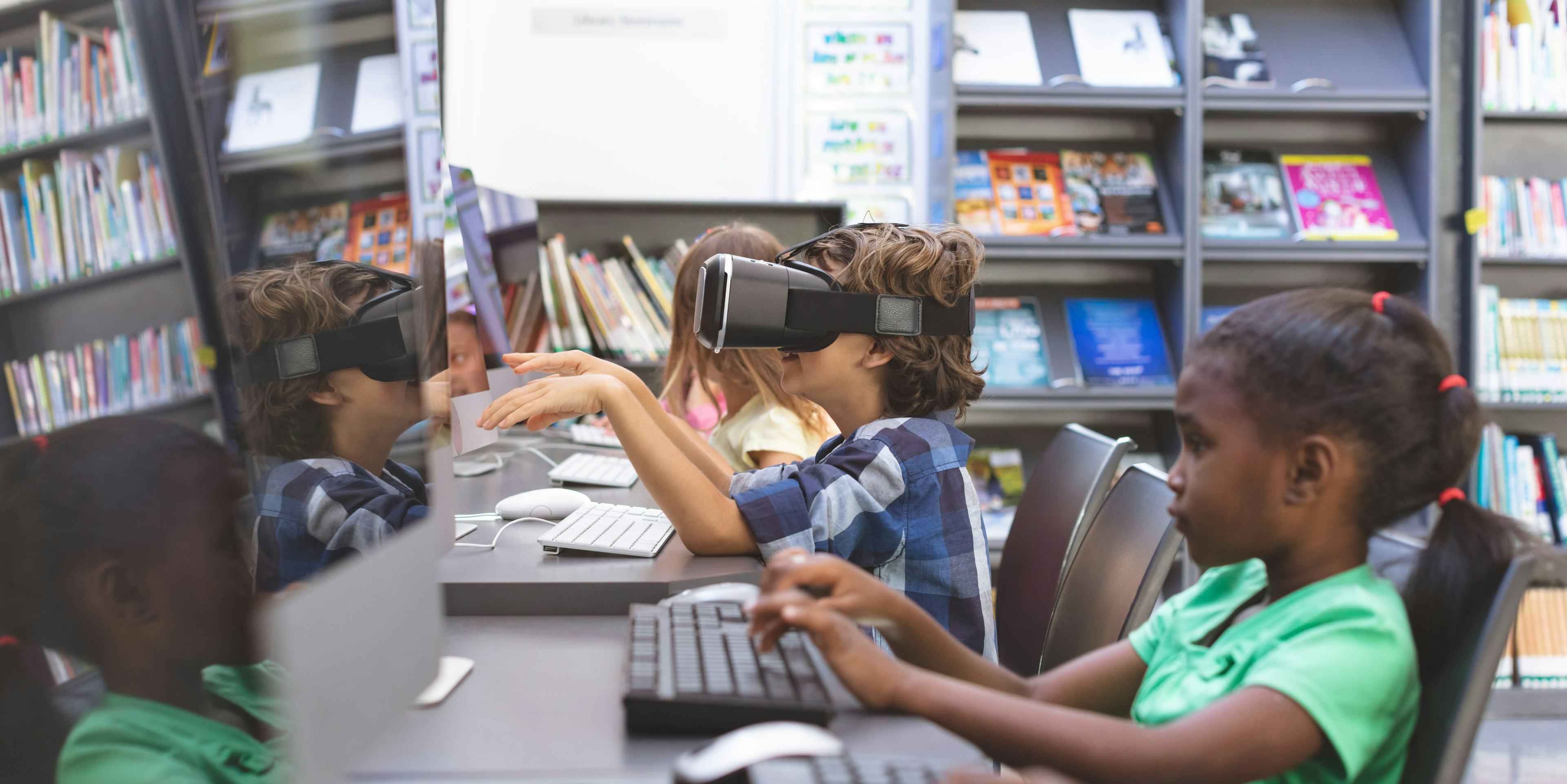 kids sitting at a desk using VR set 