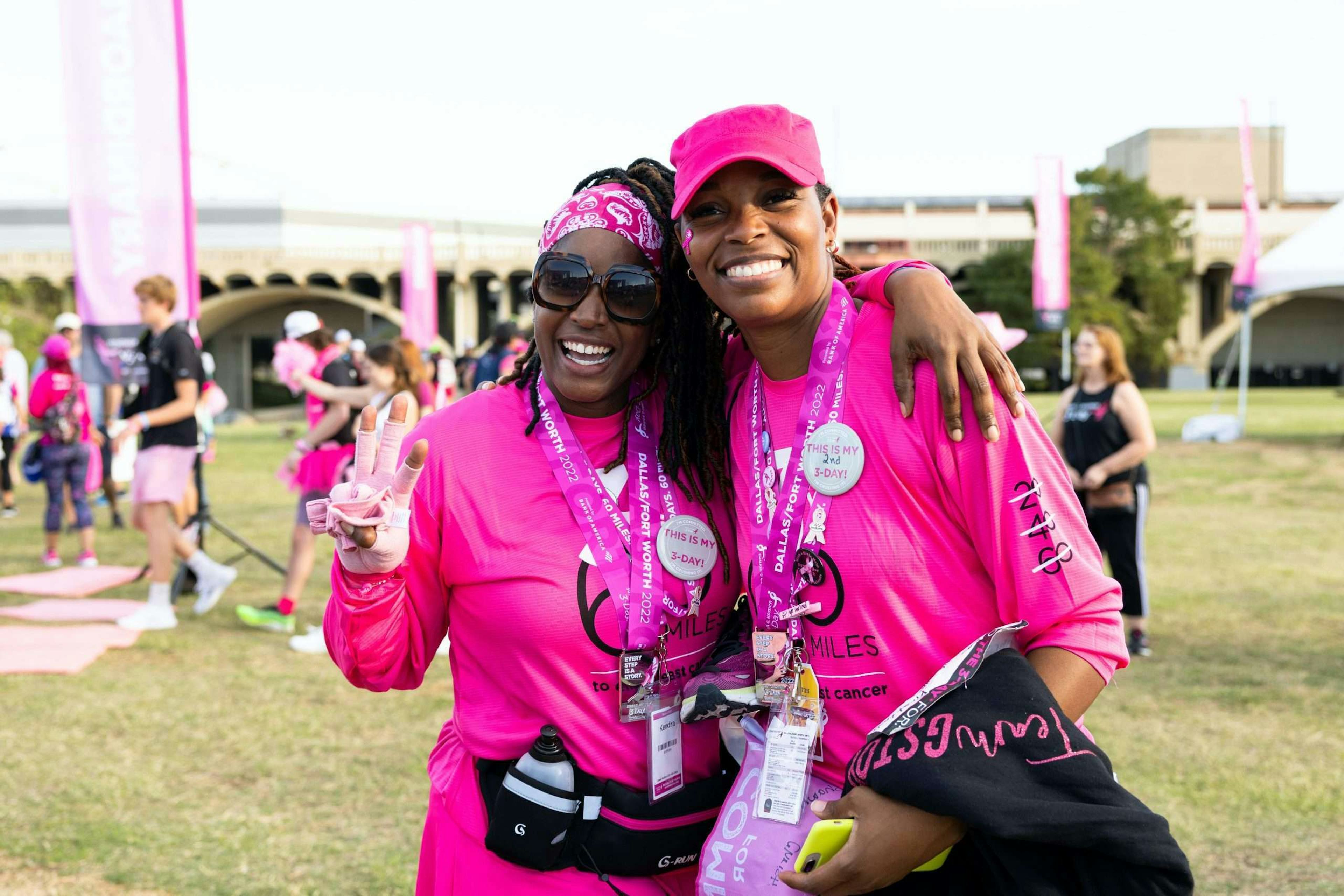 two women wearing hot pink apparel in support of Breast Cancer Awareness